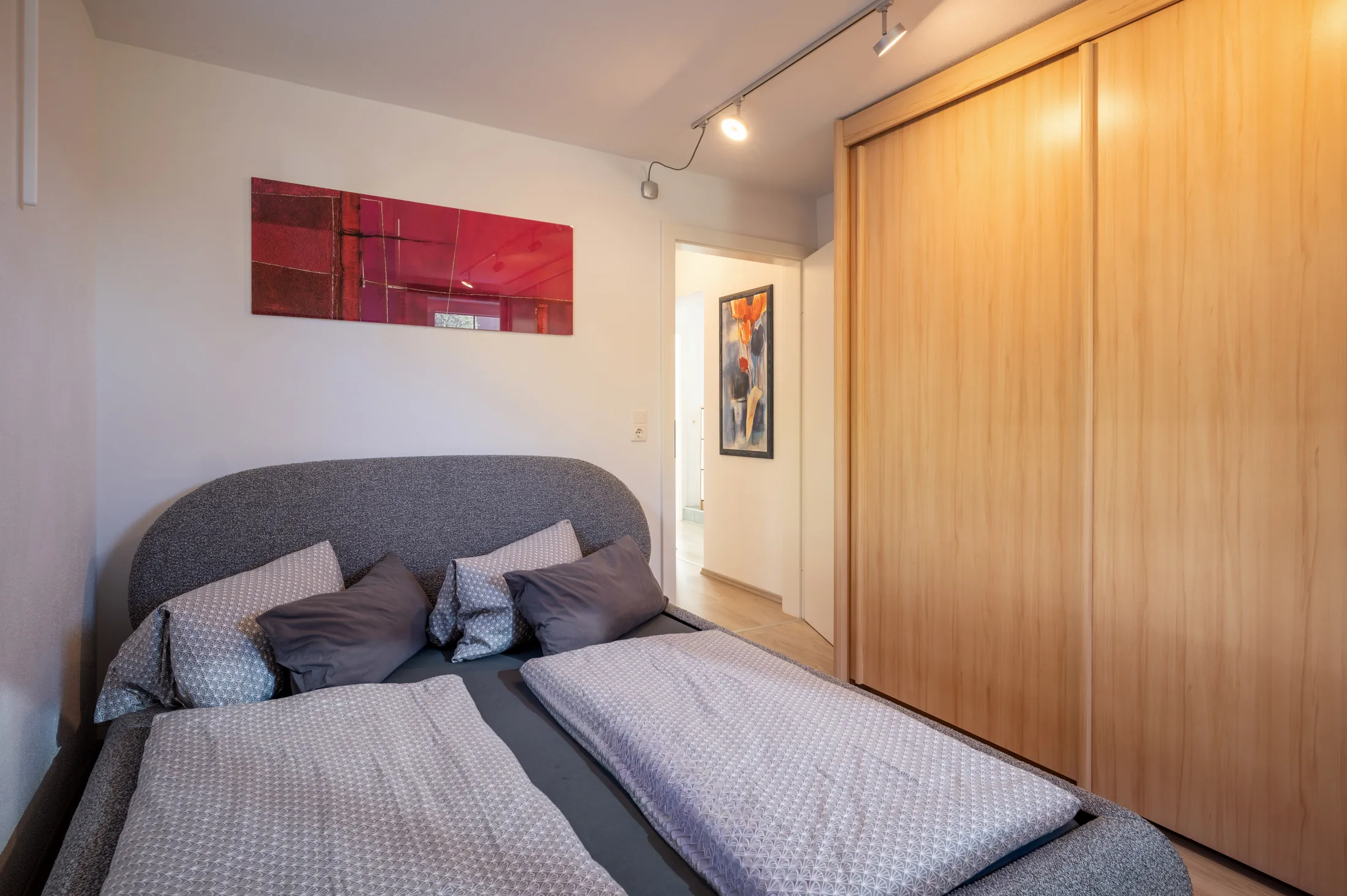 Schlafzimmer mit Doppelbett und Holzschrank